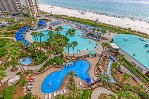 Un complexe hôtelier doté de plusieurs piscines, d’un accès à la plage et de palmiers.