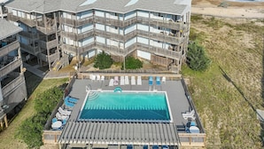 A beachfront hotel with multiple balconies, a swimming pool, and a beach view. - 7081- Sea View - Rodanthe Condo | Coastal Beach Escape (Rodanthe)