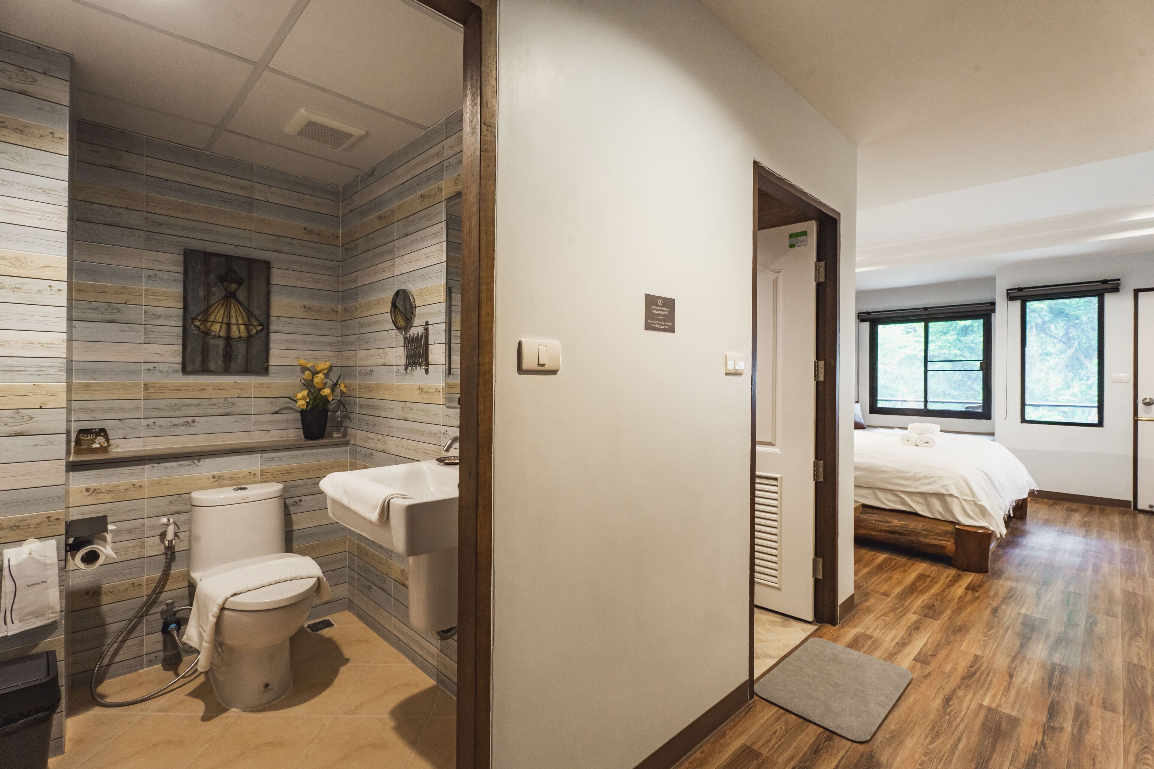 Un baño moderno con diseño de pared de madera, inodoro, lavamanos y zona de ducha.
