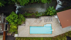 An aerial view of a rooftop pool with a clear view of the surrounding greenery and a river. - Namtok Sarika Resotel (Nakhon Nayok)