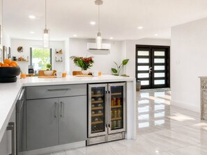A modern kitchen with a central island, stainless steel appliances, and a large refrigerator. - Villa Palma: Heart of Miami | 5 min to Miracle Mile (Miami)