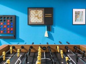 A foosball table, a Scrabble board, and a framed map on a blue wall. - Villa Palma: Heart of Miami | 5 min to Miracle Mile (Miami)