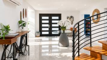 Un intérieur moderne avec un escalier, un coin repas et une grande porte.