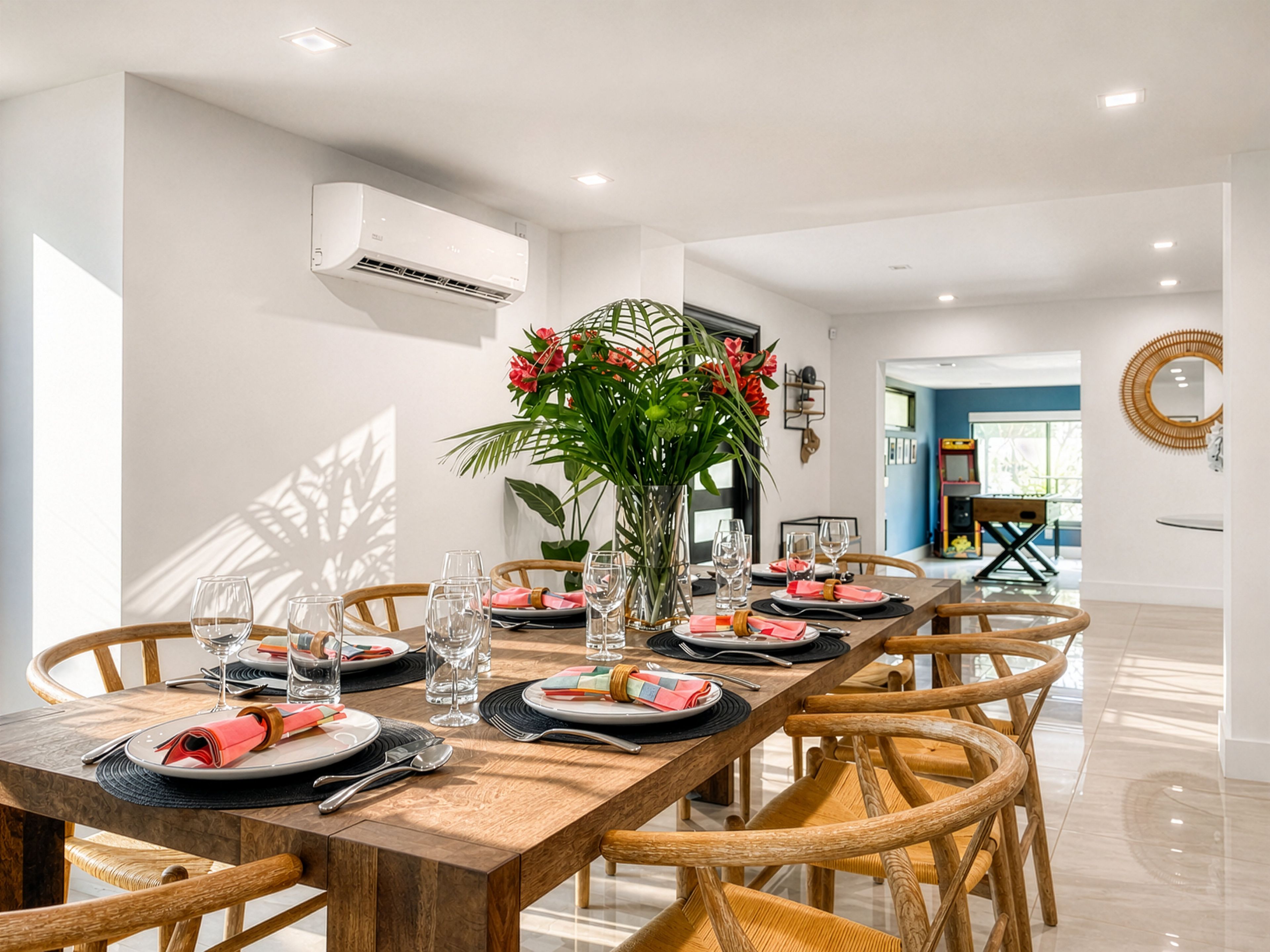 Un espace repas avec une longue table en bois dressée pour le repas, entourée de chaises en osier.