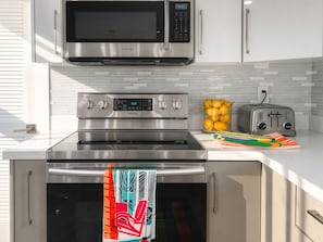 A kitchen with a stainless steel microwave, oven, and toaster, along with a bowl of lemons on the counter. - Villa Palma: Heart of Miami | 5 min to Miracle Mile (Miami)