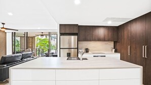 Una cocina moderna con armarios de madera oscura, una isla grande y un horno empotrado.