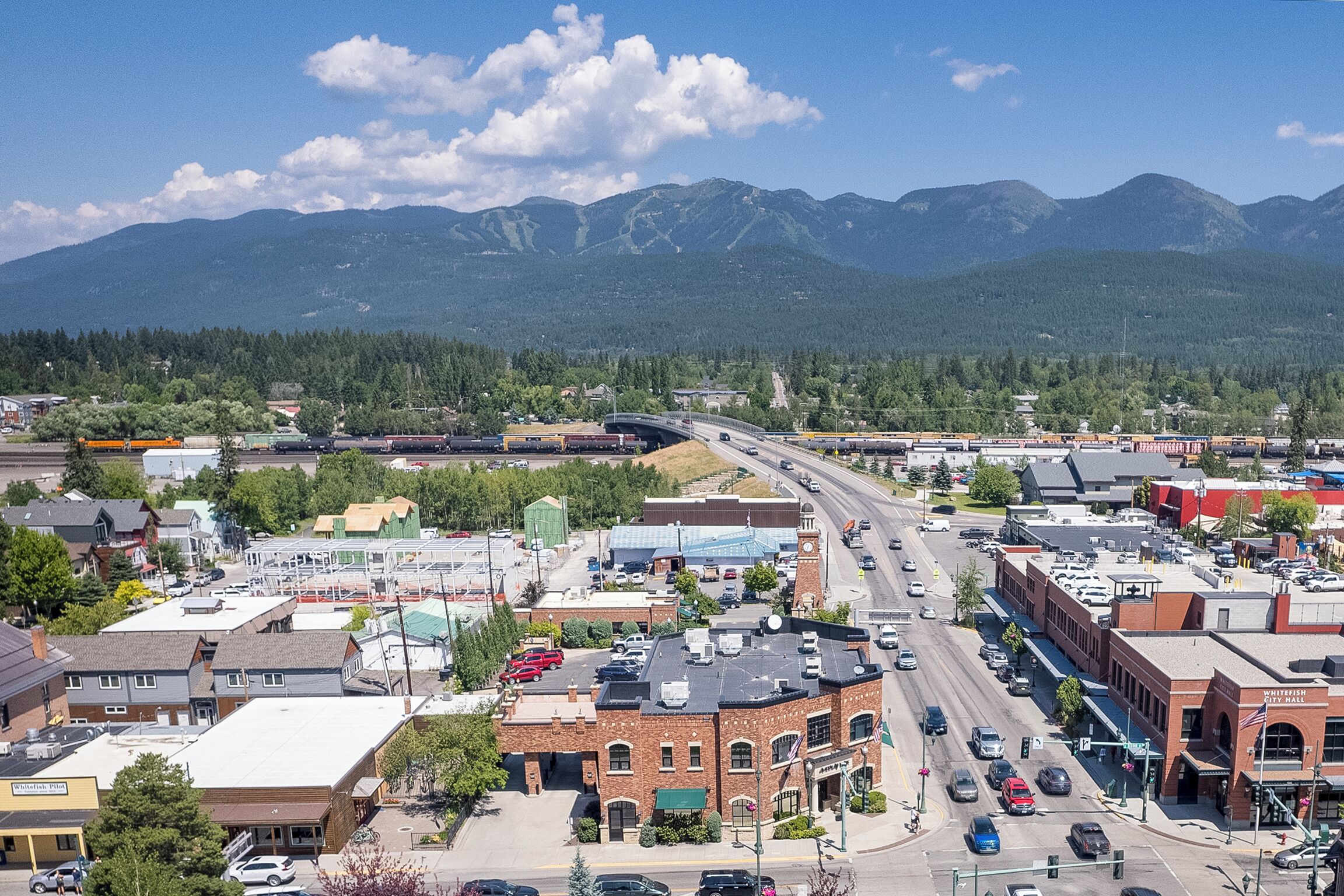 A town with a main street, buildings, and mountains in the background.