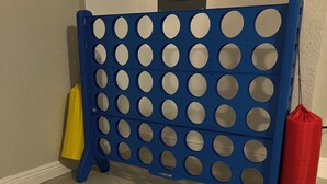 Eine blaue Lochwand, eine gelbe Tasche und eine rote Tasche vor einer Wand mit einer Tür.
