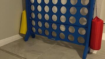 Divisória azul com recortes circulares, uma bolsa amarela e uma bolsa vermelha em frente a uma parede com porta.