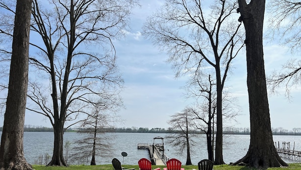 A lakeside view with four Adirondack chairs, a dock, and a gazebo. - Eagle Lake Escape - lakefront - private lot (Vicksburg)