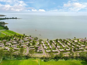 A coastal resort with multiple bungalow-style accommodations, a marina, and a large body of water. - Sustainable Holiday Home on the Ijsselmeer (Enkhuizen)