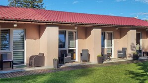 A building with a red roof, large windows, and outdoor seating. - 1 bedroom pet friendly home in Rekowo (Rekowo)