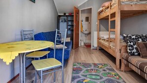 A compact room with bunk beds, a small table with chairs, a sofa, and a colorful road map rug. - 1 bedroom pet friendly home in Rekowo (Rekowo)