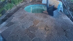 A covered outdoor area with a stone pool, seating, and a pergola with lights. - Inlaquesh Villa Atitlan (Sololá)