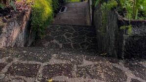 A stone staircase leading to a covered area with a view of the sea. - Inlaquesh Villa Atitlan (Sololá)