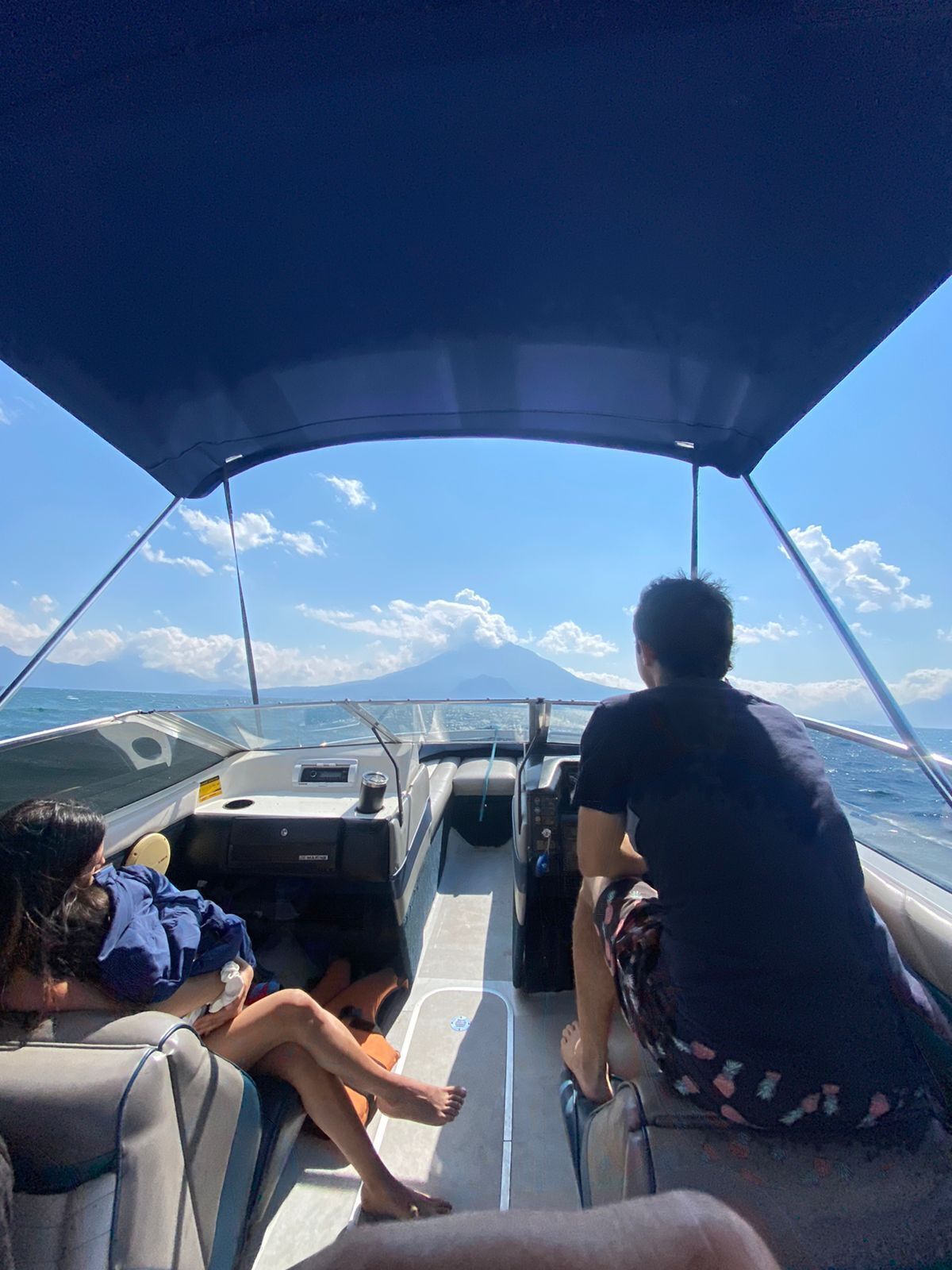 A boat interior with a clear view of the ocean and a distant mountain.