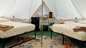 A tent with two beds, a central pole, and a small kitchenette area. - 2 Queen-Bed Canvas Bell Tent on Working Farm in Historic Laurel Highlands (Smithfield)