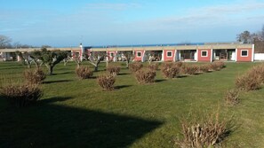 Une rangée de bâtiments rouges et blancs, avec une pelouse verdoyante et des arbustes devant.
