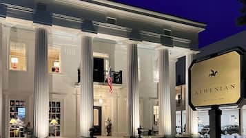 A historic inn with a grand entrance, large columns, and a flag.