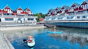 A waterfront area with red buildings, a dock, and a calm water body. - Luxury holiday home with sea view (Gråsten)