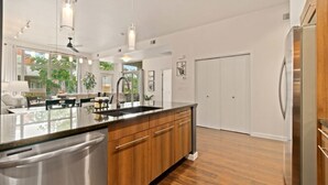 A modern kitchen with a large island, stainless steel appliances, and wooden cabinetry. - The Cozy Corner Retreat 15 min Walk to Old Town (Fort Collins)