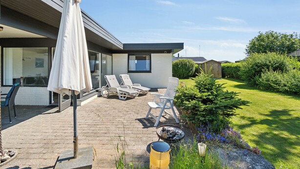 A modern house with a patio, outdoor seating, and a garden. - Atmospheric summer cottage at Hejlsminde (Hejls)