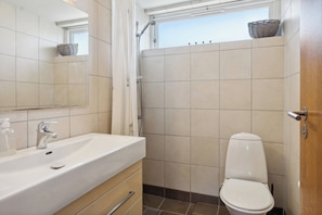 A bathroom with a sink, mirror, and toilet.