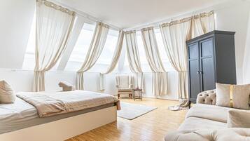 Ein Schlafzimmer mit einem Bett, einem Kleiderschrank, einem Sessel und einem Schlafsofa.