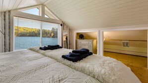 A bedroom with a large bed, a window with blinds, a dresser, and a mirror. - Overwater Bliss | Private Dock + 4 Min to Sunapee (Newbury)