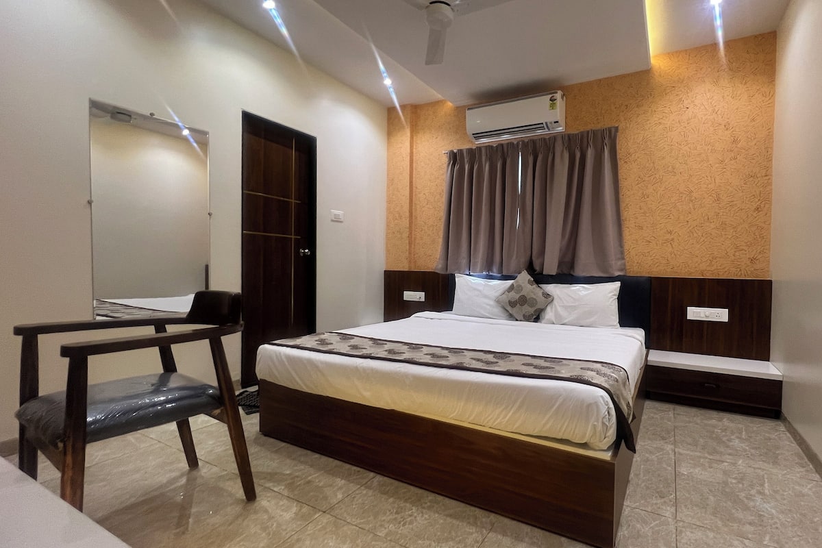Una habitación de hotel moderna con una cama de madera, un escritorio y un espejo grande.
