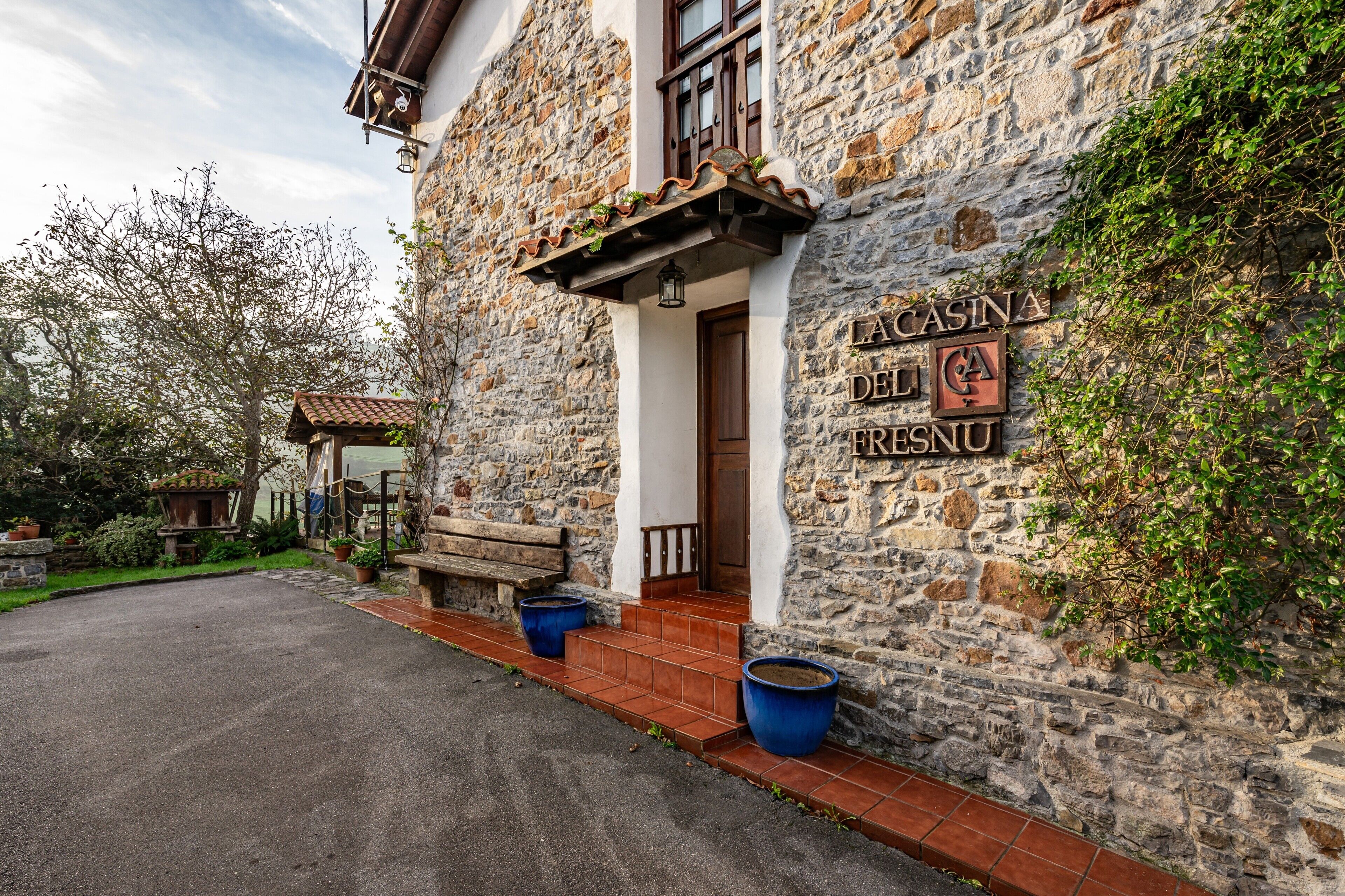 Un edificio de piedra con un letrero que dice 'LA CASINA DEL FRESNU'.
