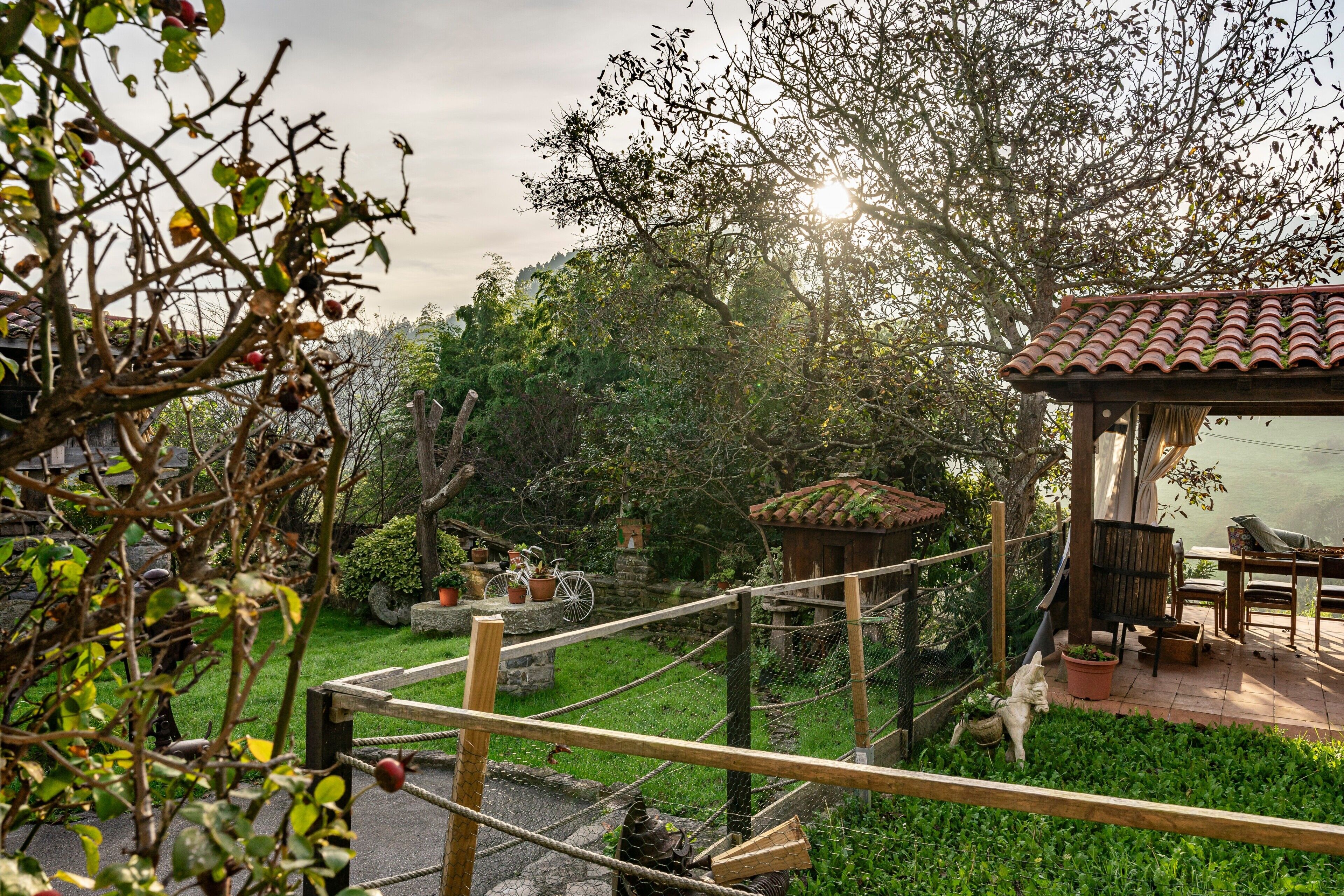 A garden with a wooden pergola, a gazebo, and a stone pathway.