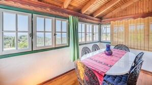A dining area with a table, chairs, and a view of the outdoors. - Holiday Home 'Priest's Traditional Mansion' with Sea View, Shared Terrace and Wi-Fi (Corfu)