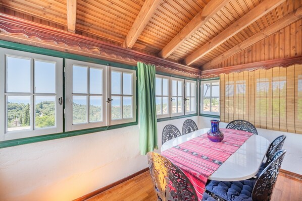 A dining area with a table, chairs, and a view of the outdoors.