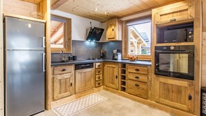Une cuisine moderne avec des meubles en bois, des appareils en acier inoxydable et un four à micro-ondes encastré.
