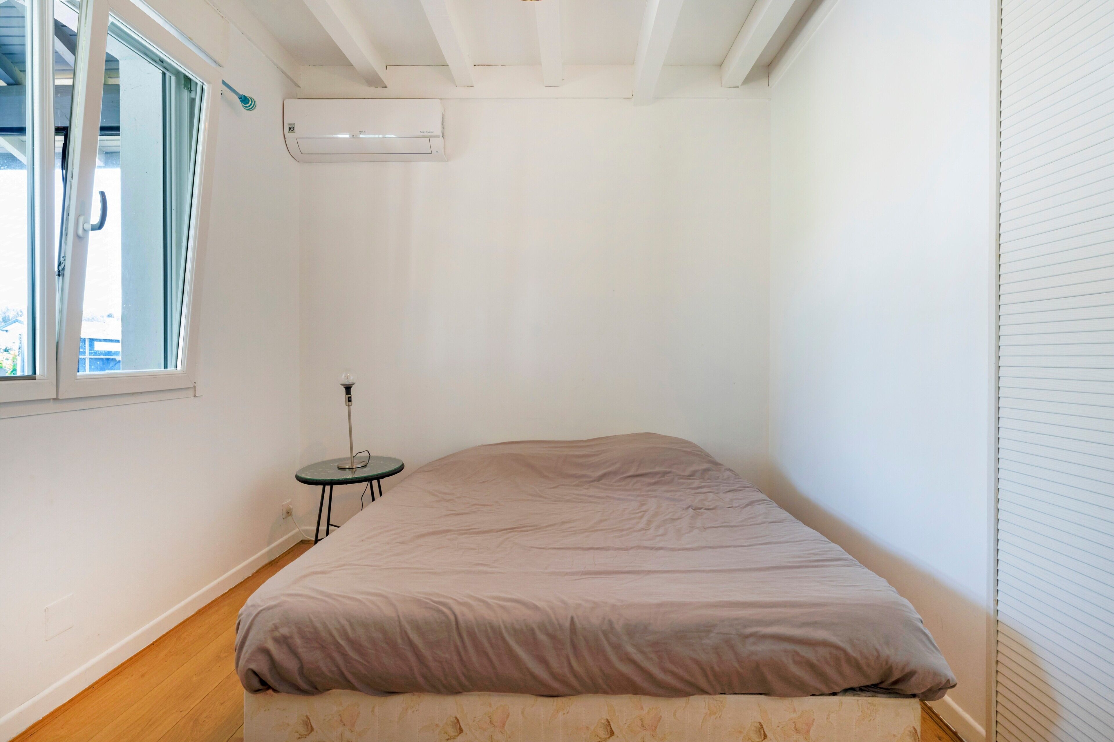 Una camera da letto con un letto, un tavolino e una finestra.