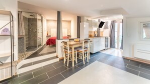 Een moderne keuken met een eethoek, douche en zithoek.
