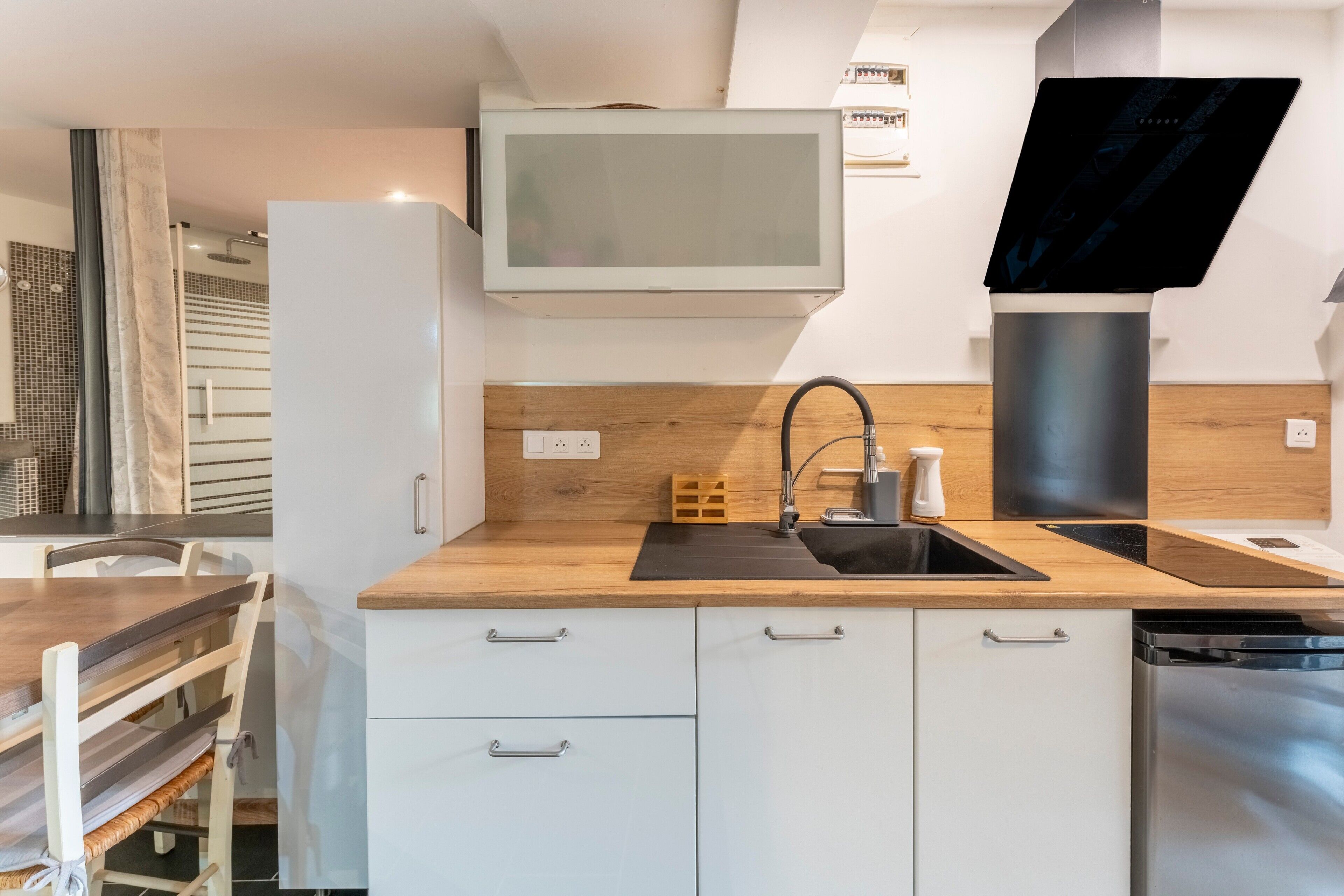 A modern kitchen with a built-in microwave, a sink, and a dishwasher.