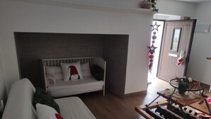 A cozy room with a white sofa, a wooden coffee table, and a small wooden stool.