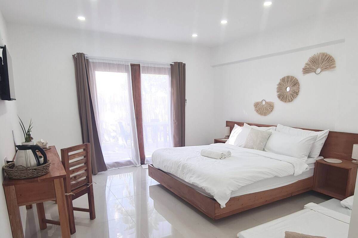 Una habitación de hotel moderna con una cama grande, un escritorio y una silla.