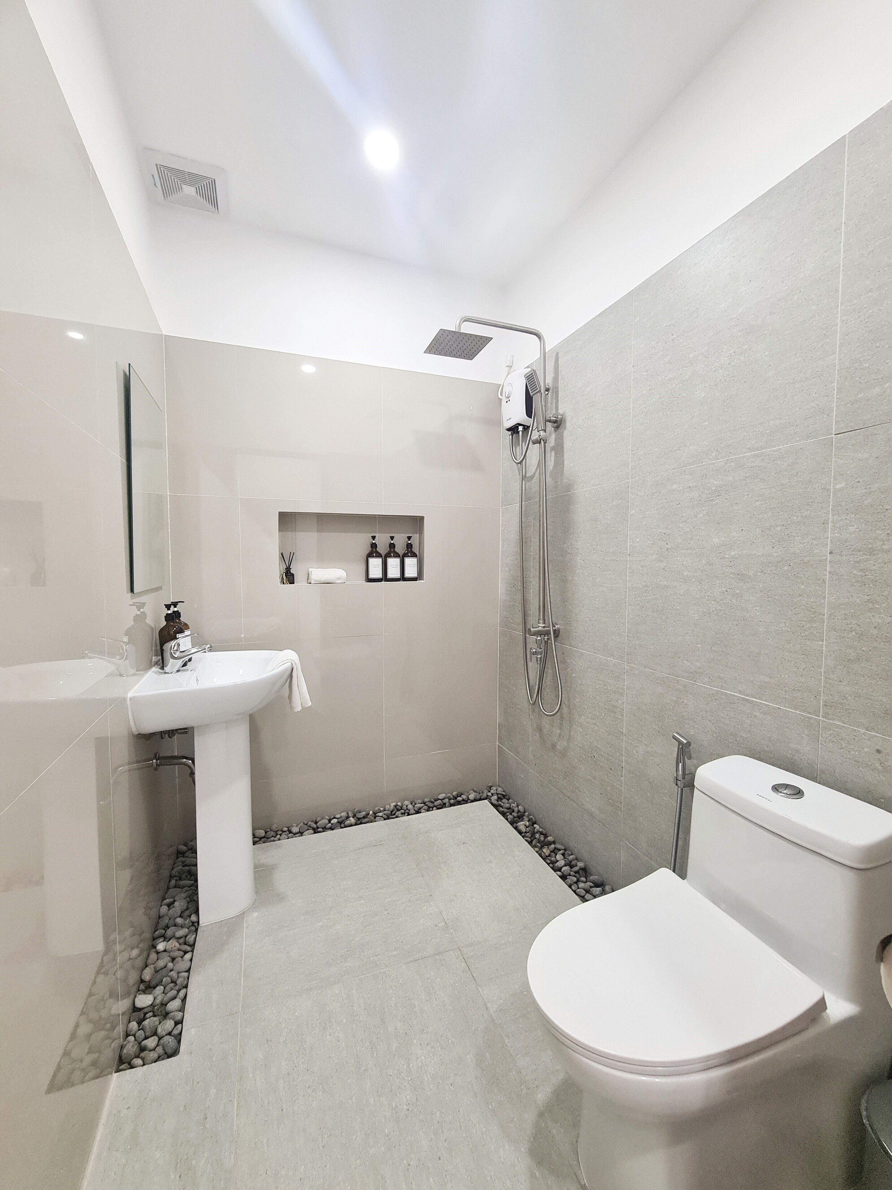 A modern bathroom with a toilet, sink, and shower.