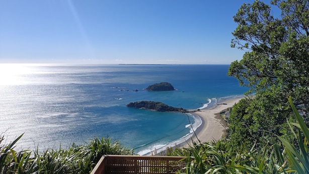 A coastal view with a beach, ocean, and a small island. - Best position in Mt Maunganui, quiet yet central. 300 m from beach & Pilot Bay (Mount Maunganui)