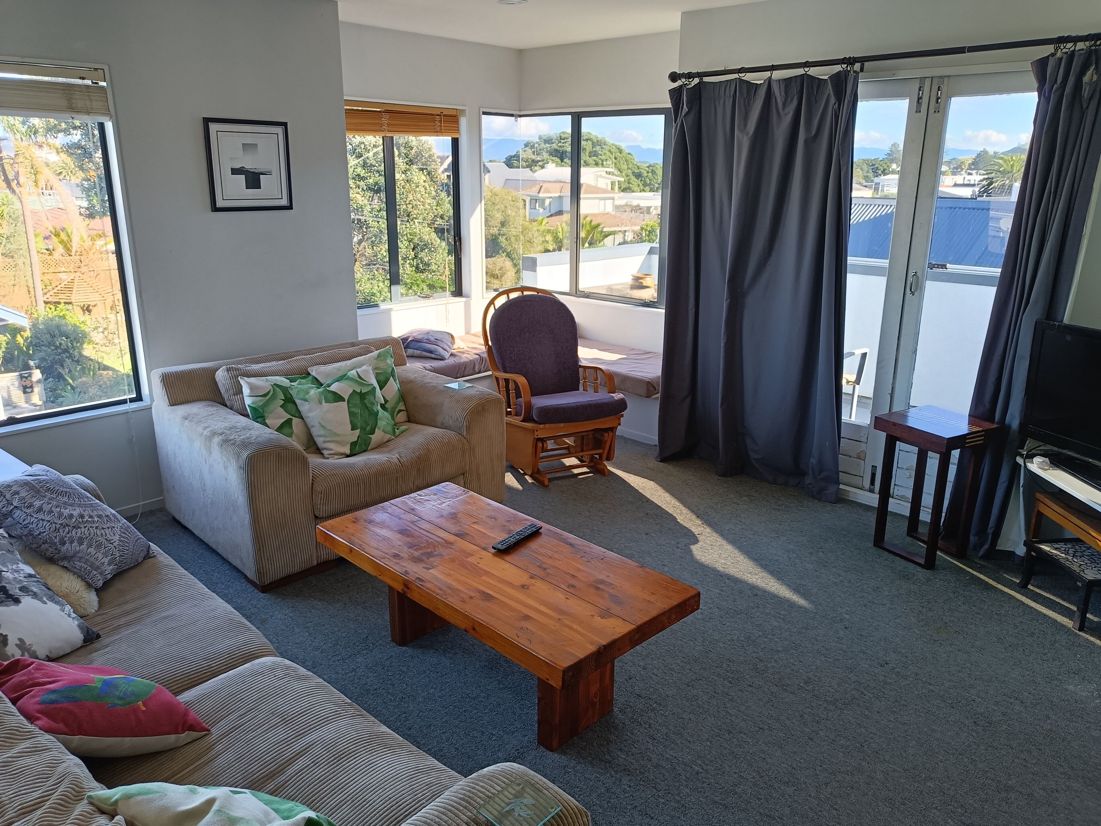 Una sala de estar con sofá, sillón y mesa de centro de madera.