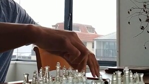 A person playing chess on a wooden table near a window with a view of buildings. - Best position in Mt Maunganui, quiet yet central. 300 m from beach & Pilot Bay (Mount Maunganui)