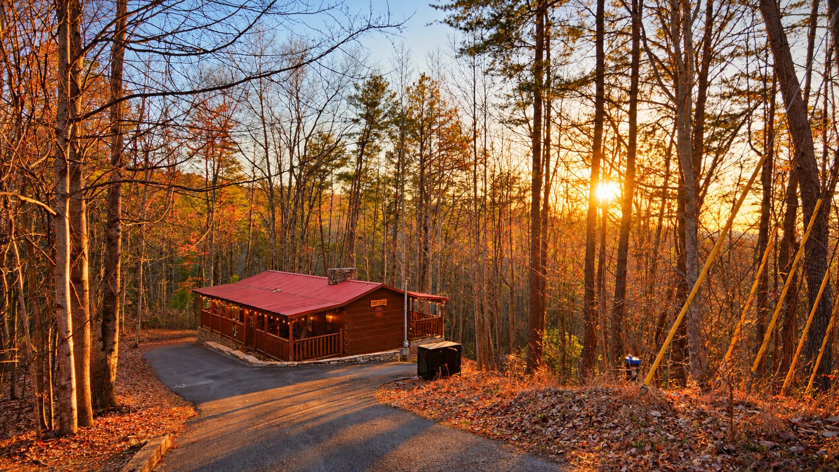 Une cabane avec un toit rouge, entourée d’une forêt, et une allée pavée menant à celle-ci.