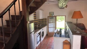 Una cocina equipada con lavadora, estufa y comedor con mesa y sillas.