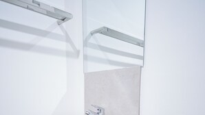 Een moderne badkamer met een wit wastafel, een houten aanrecht en een spiegel erboven.