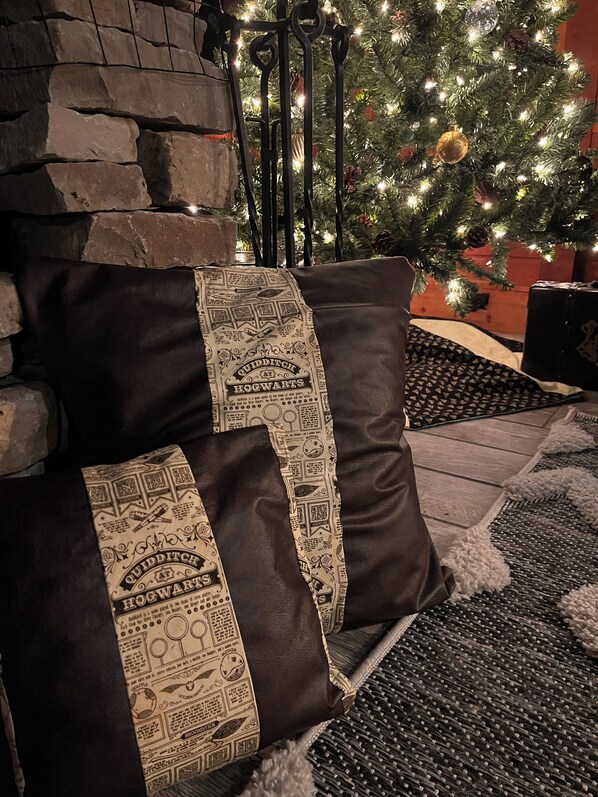 A cozy seating area with a stone wall and a decorated Christmas tree in the background.