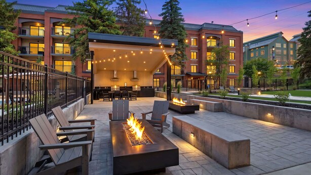 A patio area with outdoor seating, a fire feature, and a covered seating area. - Central Park City | Pool + Patio Access (Park City)
