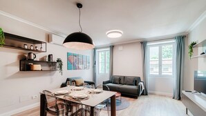A modern living space with a dining area, sofa, and TV. - Marinetti Suite 7 - MyHomeinComo (Como)
